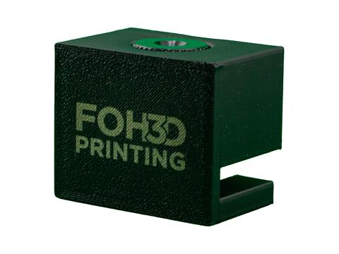 Three-quarter view of the green camera adapter with FOH3D logo and tripod insert